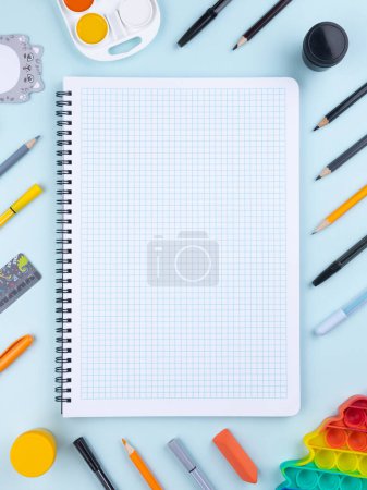 Photo for Flat lay office desk with a blank page of a notebook with a pen, pencils, watercolor and other stationery. Top view, flat lay. - Royalty Free Image