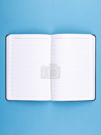 Photo for Empty open notebook on a blue background, close up. Design concept - Royalty Free Image