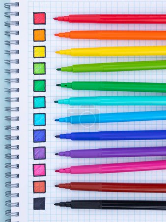 Foto de Conjunto multicolor de rotuladores con muestras de color en un cuaderno - Imagen libre de derechos