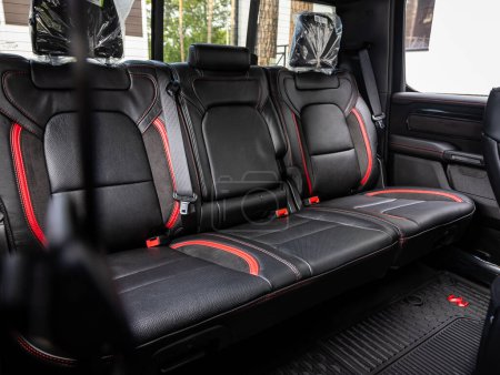 Foto de Novosibirsk, Rusia - 11 de septiembre de 2023: Dodge Ram Trx, Clean car interior: asientos traseros negros y rojos, reposacabezas y cinturón - Imagen libre de derechos