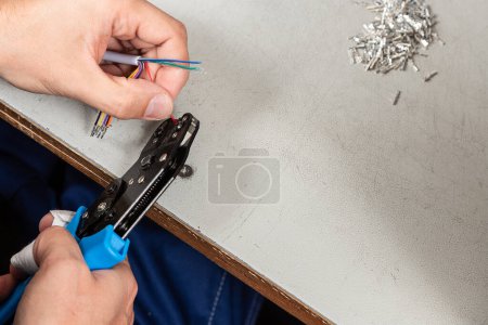 Photo for Male mechanic processes wires.  The work process of an electrician at the workplace. electrician's hands close-up cleaning wire insulation - Royalty Free Image