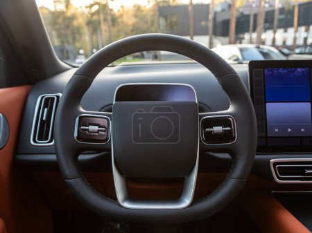 Téléchargez les photos : Intérieur de la voiture - volant et tableau de bord, indicateur de vitesse, affichage dans une voiture neuve - en image libre de droit