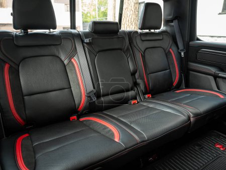Foto de Novosibirsk, Rusia - 11 de septiembre de 2023: Dodge Ram Trx, Clean car interior: asientos traseros negros y rojos, reposacabezas y cinturones - Imagen libre de derechos