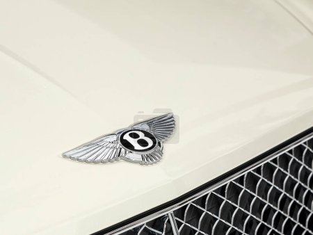 Foto de Novosibirsk, Rusia - 03 de noviembre de 2023: Bentley Bentayga, primer plano del logotipo Bentley en el capó, coche blanco. - Imagen libre de derechos