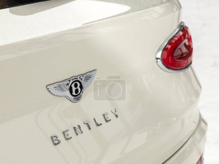 Foto de Novosibirsk, Rusia - 03 de noviembre de 2023: Bentley Bentayga, primer plano del logotipo Bentley en el maletero, coche blanco. - Imagen libre de derechos