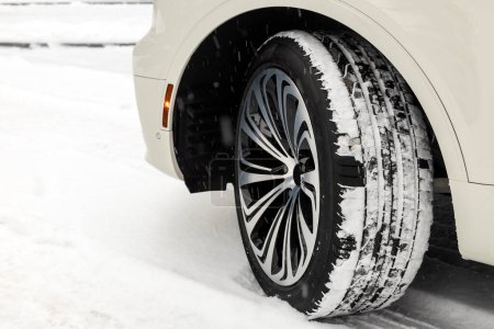 Foto de Rueda trasera con un disco de aleación y nuevos neumáticos de verano en un coche en la temporada de invierno en la nieve, primer plano. Disco de ajuste de rueda - Imagen libre de derechos