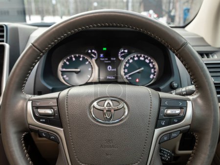 Foto de Novosibirsk, Rusia - 10 de noviembre de 2023: Toyota Land Cruiser Prado blanco, car Interior - volante, palanca de cambios y tablero de instrumentos, control de temperatura, velocímetro, pantalla. Salón de una nueva ca con estilo - Imagen libre de derechos