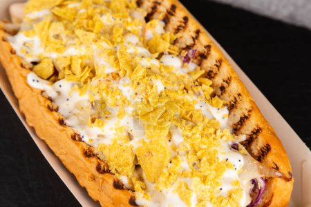 Téléchargez les photos : Hot-dogs grillés gastronomiques avec poulet, sauce et poivrons, oignons et frites.Hot-dogs savoureux frais - en image libre de droit