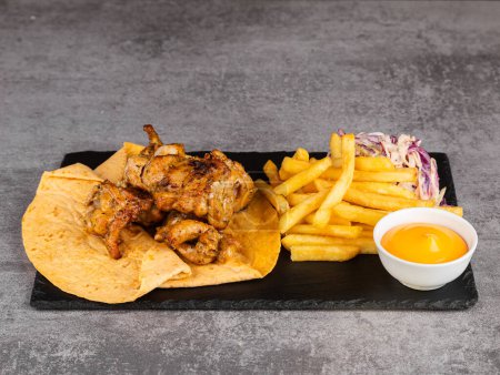 Photo for Chicken kebab with vegetables, fries and sauce on lavash - Royalty Free Image