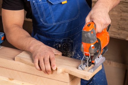 Foto de Un carpintero usando un rompecabezas para cortar madera corta barras. - Imagen libre de derechos