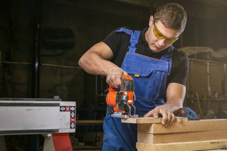 Foto de Un carpintero usando un rompecabezas para cortar madera corta barras. - Imagen libre de derechos