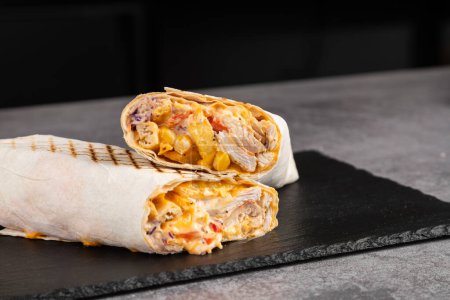Téléchargez les photos : Shawarma de poulet, rouleau frais, pellicule de viande grillée et pellicule de laitue avec sauce blanche. Donateur turc Kebab sur pain pita - poulet Shawarma. - en image libre de droit