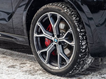 Foto de Novosibirsk, Rusia - 20 de noviembre de 2023: BMW X6, rueda de coche de primer plano con rueda de aleación de aluminio y neumático nuevo - Imagen libre de derechos