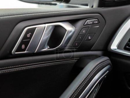 Foto de Novosibirsk, Rusia - 20 de noviembre de 2023: BMW X6, Interior del automóvil moderno. Botones laterales de la puerta: ventana, botones de ajuste del espejo, cerradura de la puerta. Coche dentro - Imagen libre de derechos
