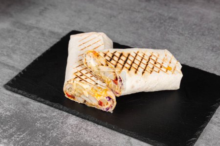 Foto de Delicioso shawarma de pollo con salsa teriyaki, verduras y papas fritas en una tabla de cortar - Imagen libre de derechos