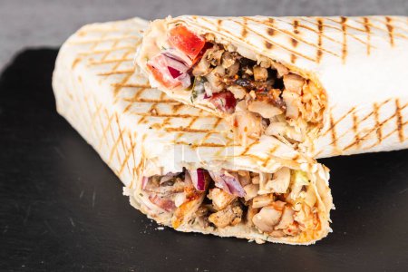 Téléchargez les photos : Rouleau Shawarma à la lavande avec poulet, légumes frais, sauce à la crème et frites sur fond de bois. Concentration sélective - en image libre de droit