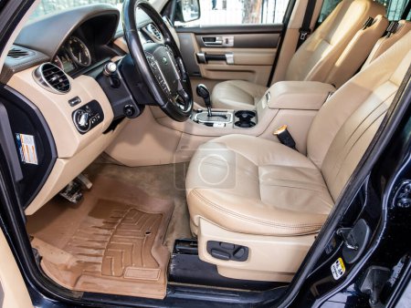 Foto de Novosibirsk, Rusia - 07 de diciembre de 2023: Land Rover Discovery 4, Interior de un nuevo SUV moderno con volante, palanca de cambios y tablero de instrumentos, control de temperatura, velocímetro, pantalla. Interior de cuero beige - Imagen libre de derechos