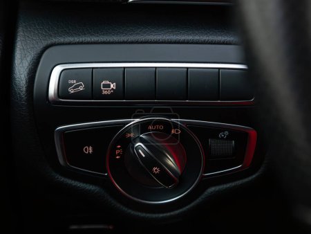 Foto de Novosibirsk, Rusia - 17 de diciembre de 2023: Mercedes-Benz V-Class, Acercamiento de los botones de control del interruptor del faro, panel de control de nivel de ajuste automático. interior del coche moderno: piezas, botones, perilla - Imagen libre de derechos