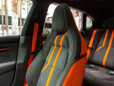 Foto de Novosibirsk, Rusia - 21 de diciembre de 2023: Zeekr 001, Asiento trasero en negro y naranja, en los asientos traseros para pasajeros con cinturones de seguridad. Interior del coche de lujo - Imagen libre de derechos