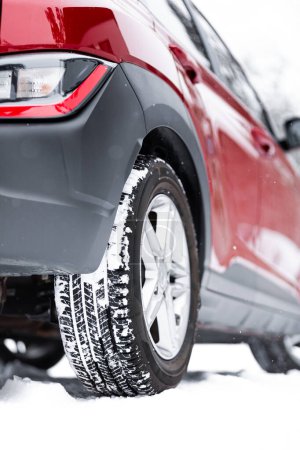 Téléchargez les photos : Gros plan d'un pneu d'hiver. Détail des pneus de voiture en hiver sur une route enneigée. - en image libre de droit