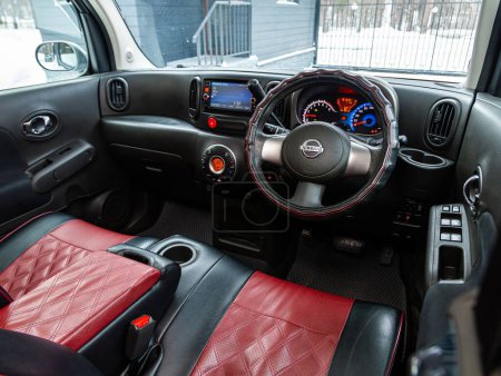 Foto de Novosibirsk, Rusia - 15 de enero de 2024: Nissan Cube plateado, volante, palanca de cambios y tablero de instrumentos, control de temperatura, velocímetro, pantalla. Salón de una nueva ca con estilo - Imagen libre de derechos