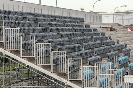 Téléchargez les photos : Amphithéâtre extérieur moderne avec rangées de chaises grises. Stade de sport - en image libre de droit