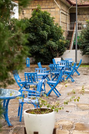 Foto de Fotografía atmosférica de verano. Mesas de madera decoradas con servilletas azules. Café de calle abierta en un estilo marino - Imagen libre de derechos