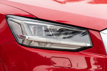 Téléchargez les photos : Gros plan de la de voiture rouge avec phare clair, pare-chocs, feux de brouillard - en image libre de droit