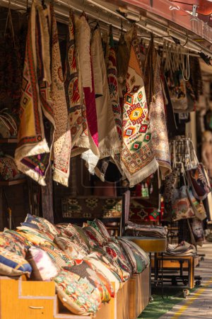 Foto de Primer plano de un bazar oriental, una tienda con varias bufandas, alfombras y almohadas con adornos - Imagen libre de derechos