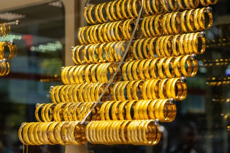Foto de Close up of the jewelry gold necklaces ring, bracelets, show in  beauty retail store window display showcase background. - Imagen libre de derechos