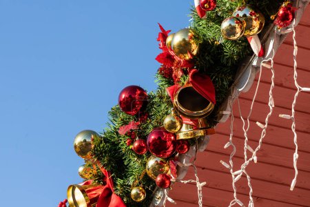Téléchargez les photos : Gros plan de boules de Noël brillantes colorées accrochées à un arbre de Noël, en arrière-plan, il y a de nombreuses guirlandes rayonnantes de différentes couleurs. Nouvel An et concept de Noël. Magnifiquement décoré arbre de Noël - en image libre de droit