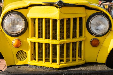 Téléchargez les photos : Gros plan de la voiture vintage jaune avec phares clairs - en image libre de droit