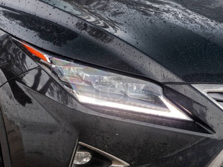 Photo for Novosibirsk, Russia - February  10 , 2024:  Lexus RX200t , Headlight of a modern   luxury car close-up. Shiny glass car headlight with glare from lightin - Royalty Free Image