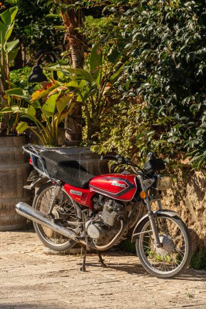 Téléchargez les photos : Côté ; Turquie 04 Février 2024 : Une moto rouge se tient dans un parking sur fond de rue - en image libre de droit