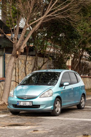 Foto de Lado; Turquía 04 de febrero 2024: azul Honda Fit Jazz está estacionado en la calle en un día cálido con el telón de fondo de un aparcamiento - Imagen libre de derechos