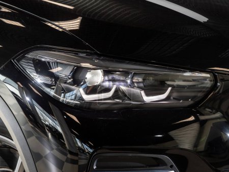 Téléchargez les photos : Novossibirsk, Russie - février 04, 2024 : BMW X5 noir, Vue macro du phare de la lampe au xénon de voiture moderne, pare-chocs, roue - en image libre de droit