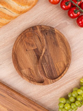 Téléchargez les photos : Assiette vide menazhnitsa faite à la main sur une table en bois décorée avec des légumes et du pain - en image libre de droit