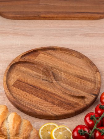 Téléchargez les photos : Assiette vide menazhnitsa faite à la main sur une table en bois décorée avec des légumes et du pain - en image libre de droit