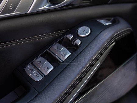 Foto de Novosibirsk, Rusia - 13 de marzo de 2024: BMW X7, primer plano de los botones laterales de la puerta: botones de ajuste de la ventana, cerradura de la puerta - Imagen libre de derechos