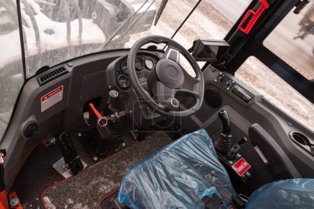 Foto de Novosibirsk, Rusia - 29 de febrero de 2024: Tractor naranja, primer plano del asiento del tractor y del interior del panel de control - Imagen libre de derechos