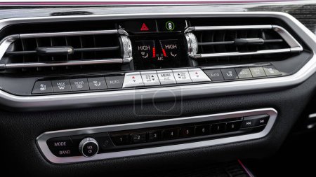 Foto de Novosibirsk, Rusia - 23 de marzo de 2024: BMW X7 negro, Moderno interior de coche negro y rojo: vista del control de climatización con botón de aire acondicionado - Imagen libre de derechos