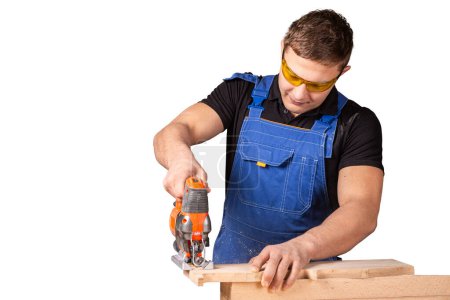 Photo for Close up of experienced carpenter in work clothes and small buiness owner  carpenter saw and processes the edges of a wooden bar with a jig saw  on white background - Royalty Free Image