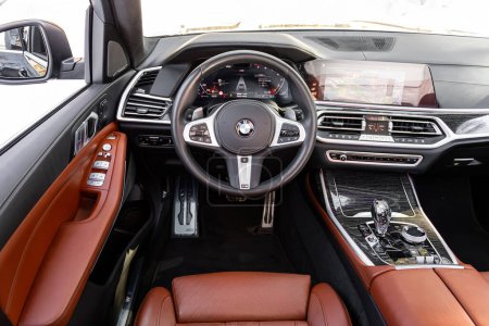 Foto de Novosibirsk, Rusia - 23 de marzo de 2024: BMW X7 negro, Interior de un nuevo SUV moderno con volante, palanca de cambios y tablero de instrumentos, control de temperatura, velocímetro, pantalla. Interior de cuero rojo - Imagen libre de derechos