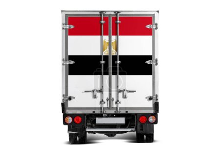 Téléchargez les photos : Un camion avec le drapeau national de l'Egypte représenté sur le hayon roule sur un fond blanc. Concept d'exportation-importation, transport, livraison nationale de marchandises - en image libre de droit
