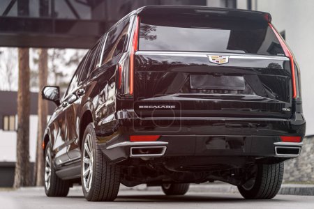 Téléchargez les photos : Novossibirsk, Russie - 30 avril 2024 : Cadillac Escalade 600 noir, vue de l'arrière, garé d'une ville. Aucune autre voiture et les gens. - en image libre de droit