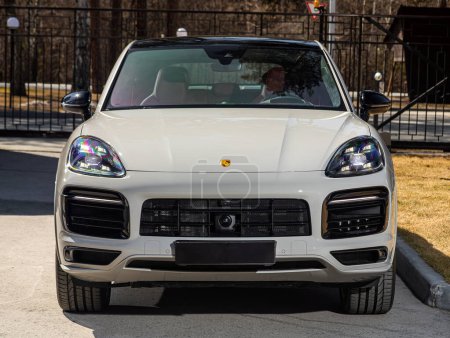 Photo for Novosibirsk, Russia -  April 30  , 2024:   white Porsche Cayenne,  front  view. SUV   car  against city in  summer time - Royalty Free Image