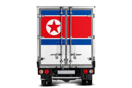 Téléchargez les photos : Un camion avec le drapeau national de la Corée du Nord représenté sur le hayon roule sur un fond blanc. Concept d'exportation-importation, transport, livraison nationale de marchandises - en image libre de droit