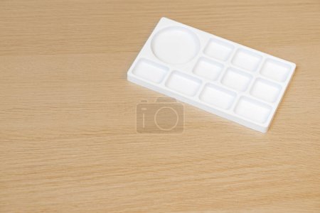 Photo for White watercolor palette. Empty watercolor tray isolated on wood background. White plastic paint palette. - Royalty Free Image