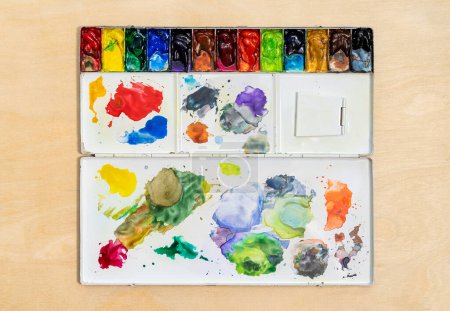 Photo for Metal watercolor palette box with colorful watercolor set on wood background. Close up. - Royalty Free Image