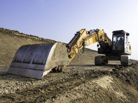 Machine de construction en action : bulldozer sur monticule de terre